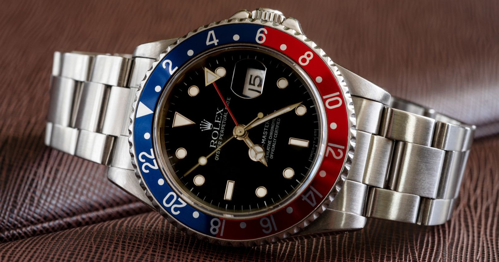 Rolex GMT-Master II Pepsi mit blau-roter Lünette und Edelstahlarmband auf Holzoberfläche