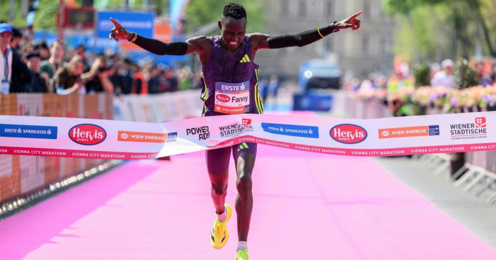 Fanny Kiprotich überquert die Ziellinie beim Vienna City Marathon und gewinnt das Rennen mit ausgebreiteten Armen in Wien