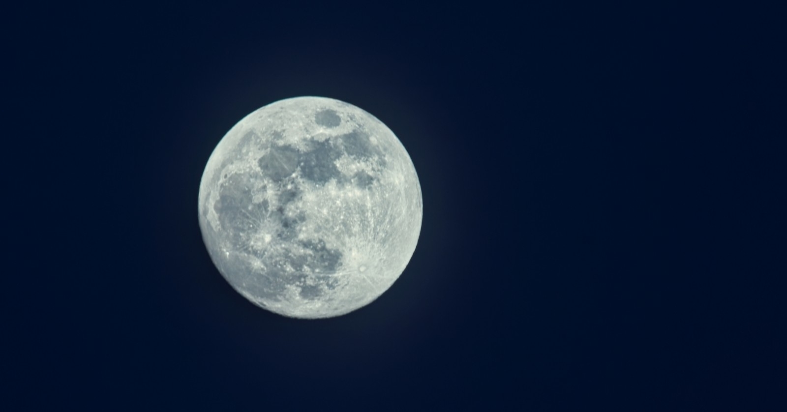 Heller Vollmond, der im dunklen Nachthimmel leuchtet, detaillierte Nahaufnahme der Mondoberfläche mit sichtbaren Kratern und Maria.