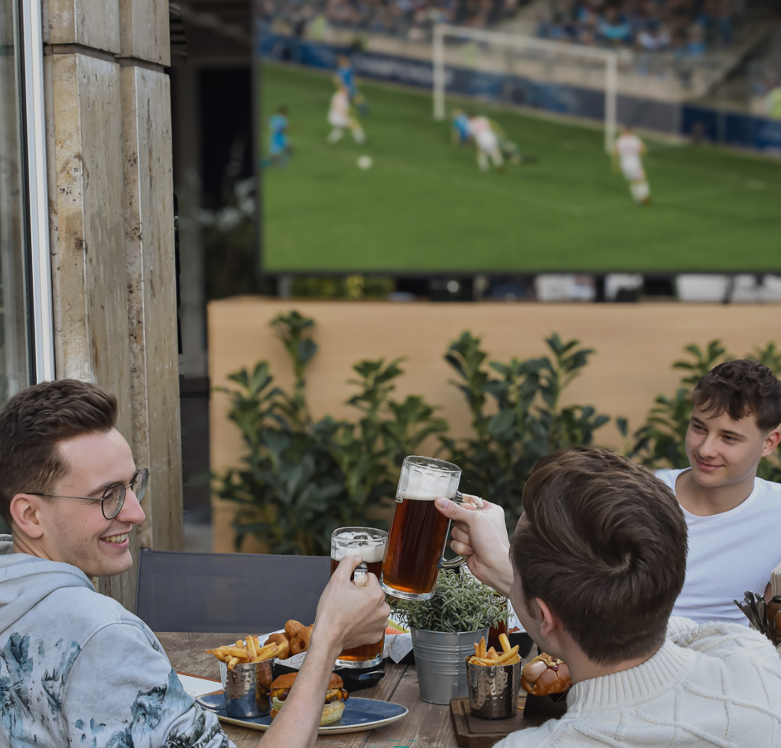 Junge Bier beim Anstoßen mit Bier während der TV-Übertragung eines Fußballspiels | Credit: Vienna Marriott Hotel