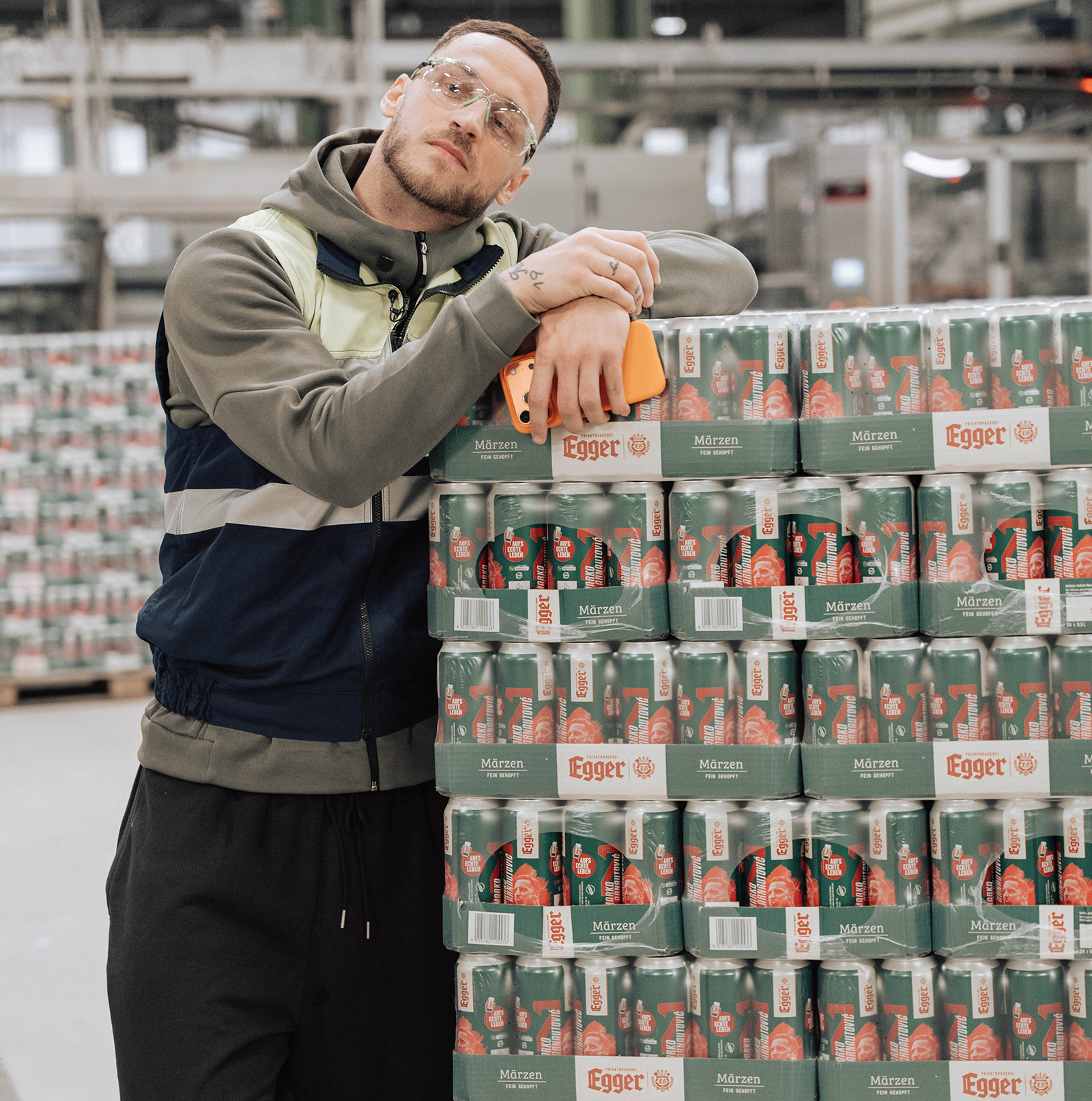 Marko Arnautović neben übereinander gestapelten Paletten Bier | Credit: Privatbrauerei Egger