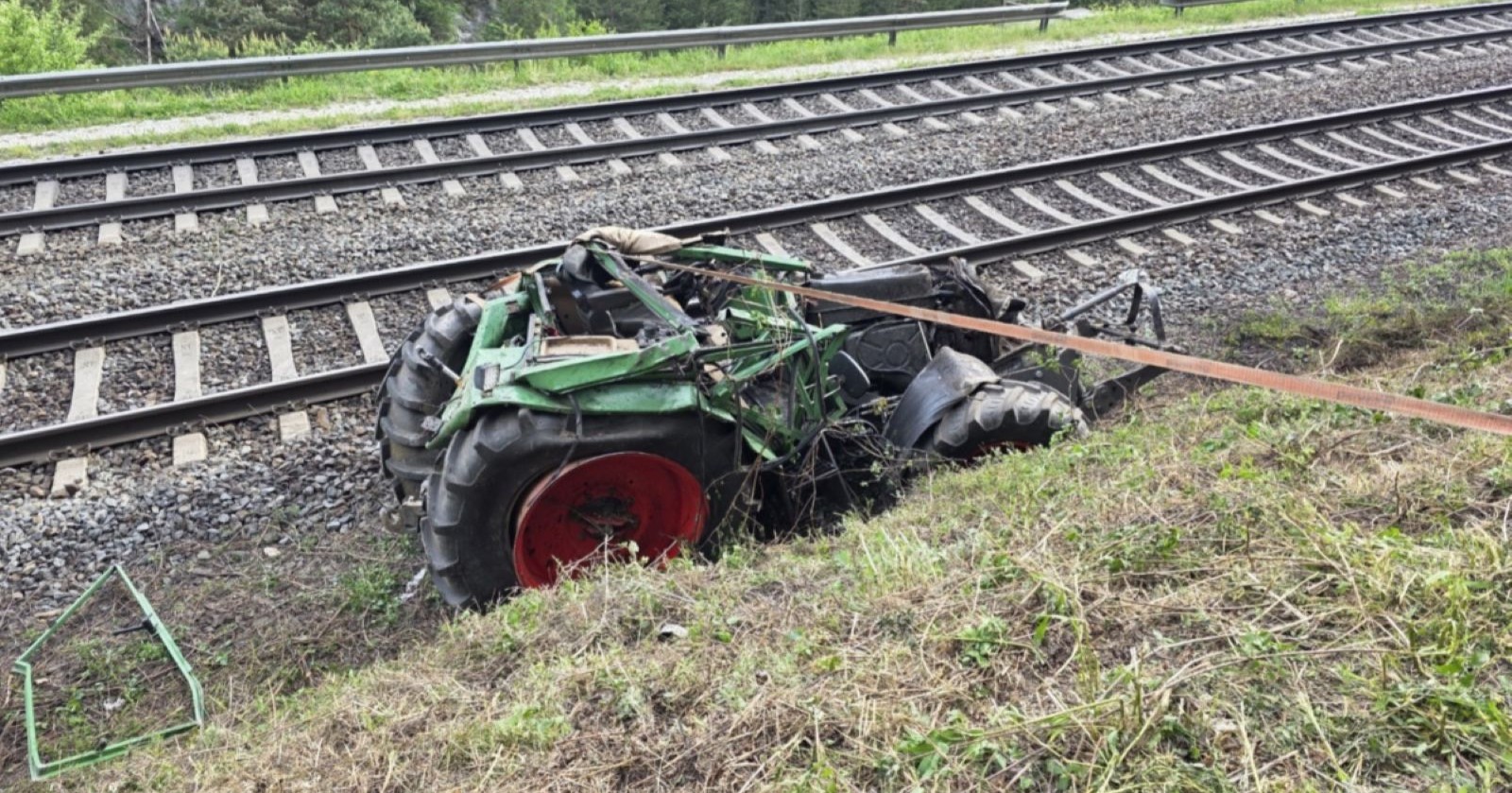 Zerstörter Traktor steht neben Zuggleisen