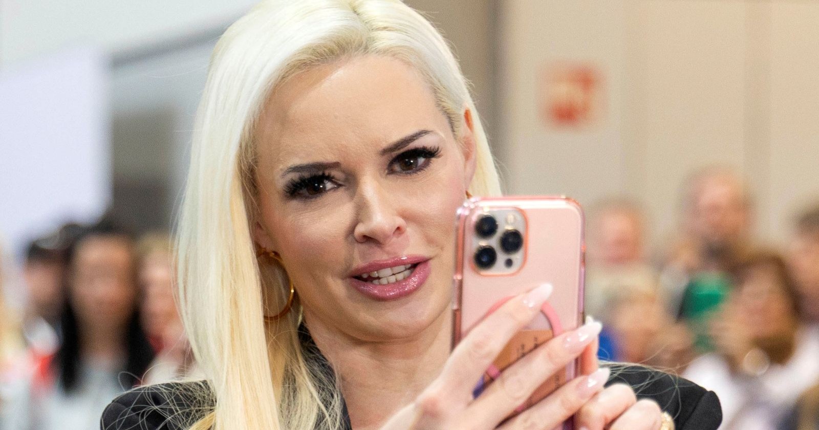 Daniela Katzenberger blickt kritisch auf ihr Smartphone und spricht offen über ihre Erfahrungen mit der Promiwelt und dem Showbusiness.