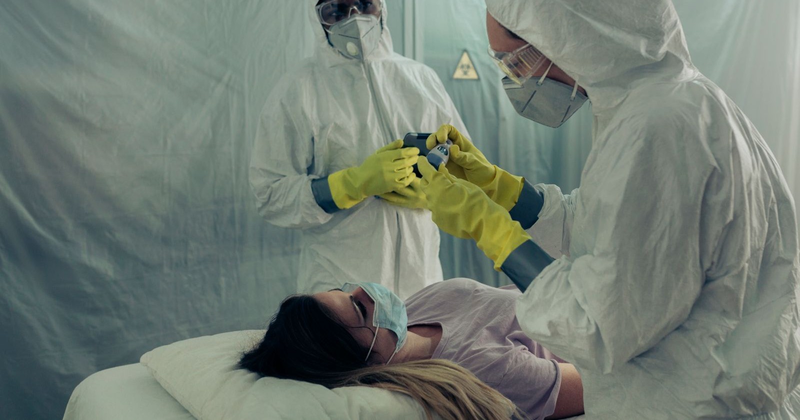 Medizinisches Personal in Schutzanzügen untersucht Patientin bei Ebola-Verdachtsfall unter strengen Sicherheitsmaßnahmen
