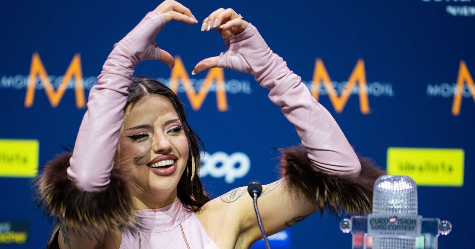 ESC-Gewinnerin Dara formt bei einer Pressekonferenz nach ihrem ESC-Sieg ein Herz mit den Händen und kündigt ihren neuen deutschen Song „Ich liebe dich“ an.