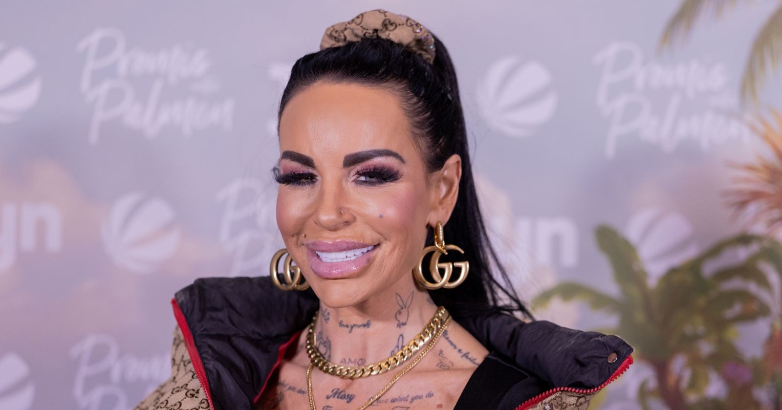 Gina-Lisa Lohfink bei einem öffentlichen Event mit schwarzen Haaren, auffälligem Make-up und goldenen Accessoires. Die Reality-TV-Bekanntheit sorgt aktuell wegen ihrer schweren Gesundheitskrise für Schlagzeilen.