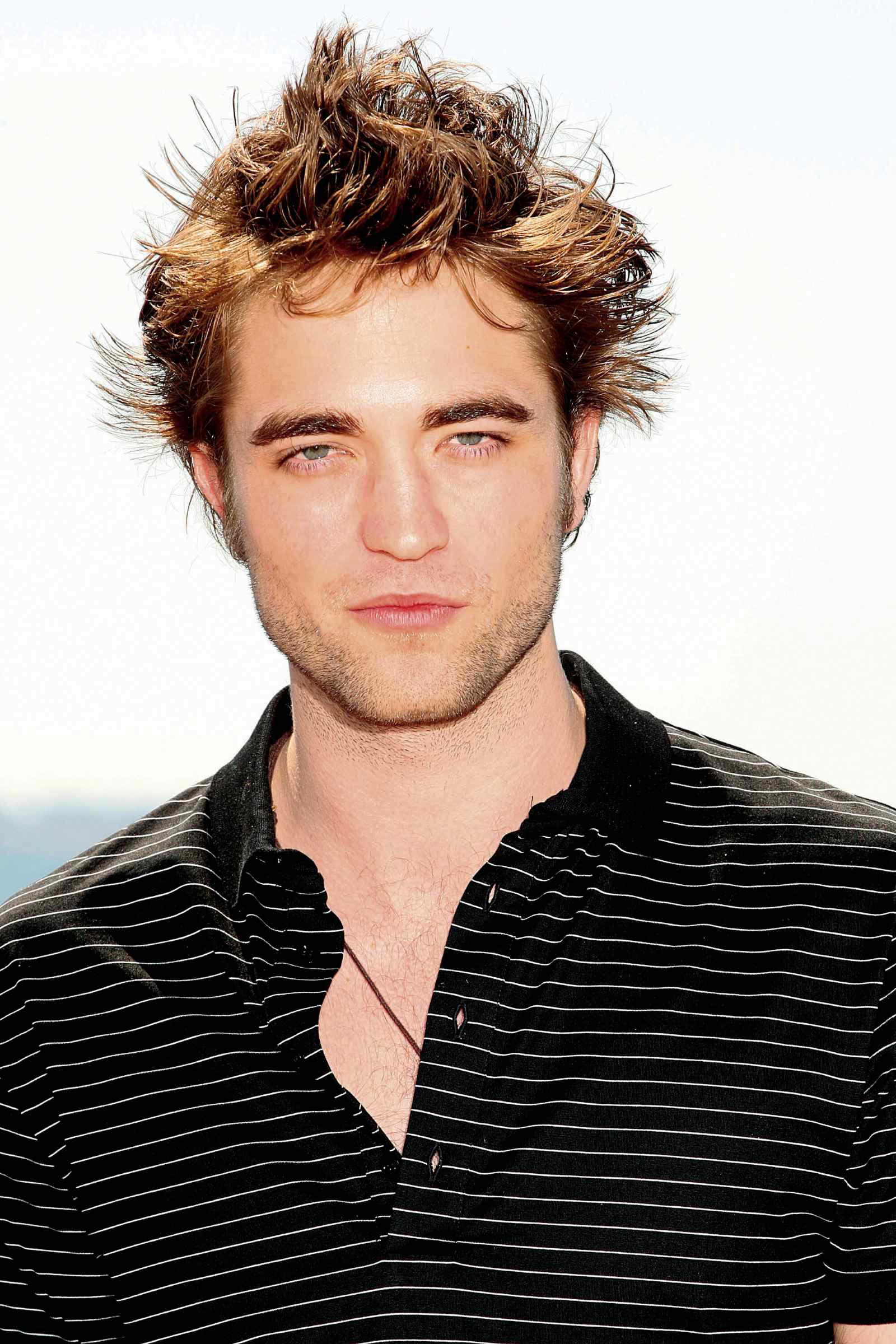 Junger Robert Pattinson mit wuscheligen Haaren und schwarzem Poloshirt bei einem Fototermin im Jahr 2009.