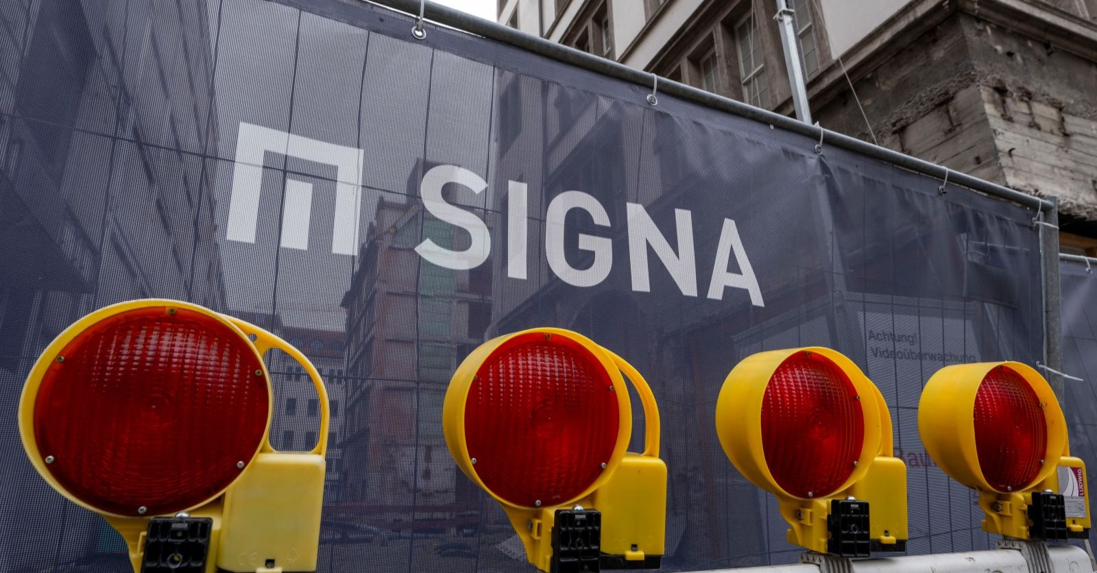 Signa Holding Baustelle mit Logo und Warnleuchten als Symbol für Insolvenz und 160 Millionen Euro Forderungen