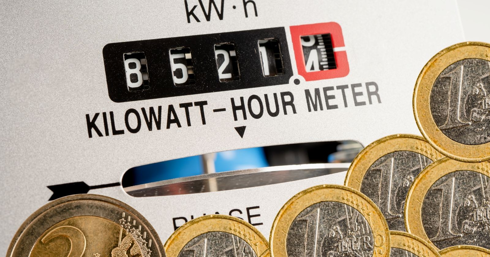 Stromzähler mit Kilowattstundenanzeige und Euro-Münzen als Symbol für Strompreise und Strompreisbremse in Österreich