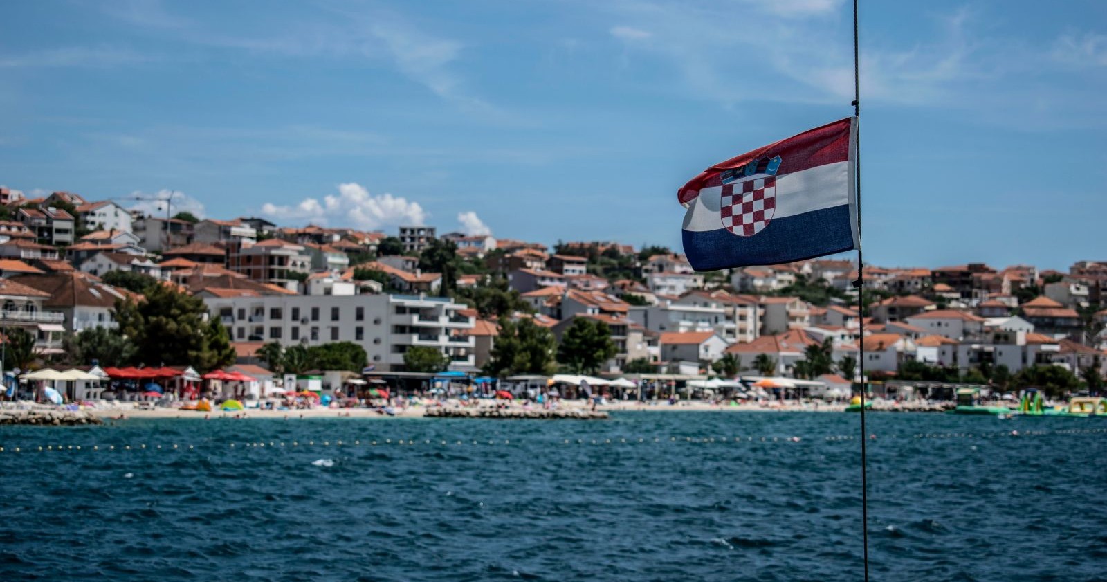 Blick auf einen Strand in Kroatien mit Ferienhäusern und Hotels.