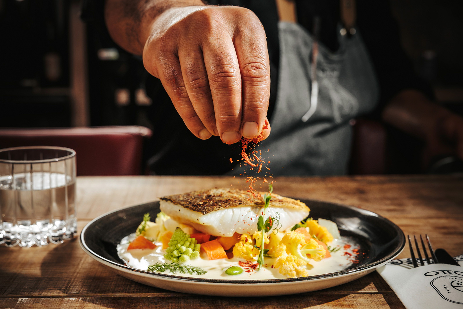 Koch beim Würzen eines Fischfilets | Credit: Philipp Lipiarski