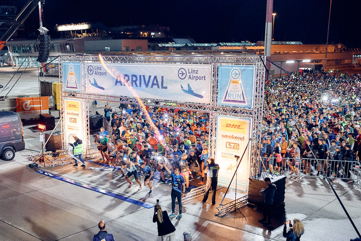 Start des 10. DHL Linz Airport Night Run am Flughafen Linz mit zahlreichen Läuferinnen und Läufern bei Nacht.