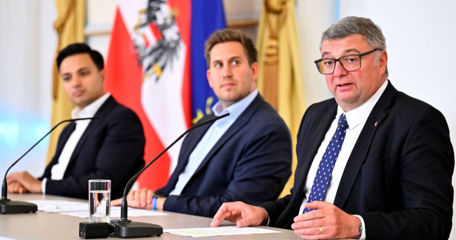Pressekonferenz zum Doppelbudget in Österreich mit Staatssekretär Alexander Pröll, NEOS-Klubchef Yannick Shetty und SPÖ-Staatssekretär Jörg Leichtfried vor österreichischen Flaggen