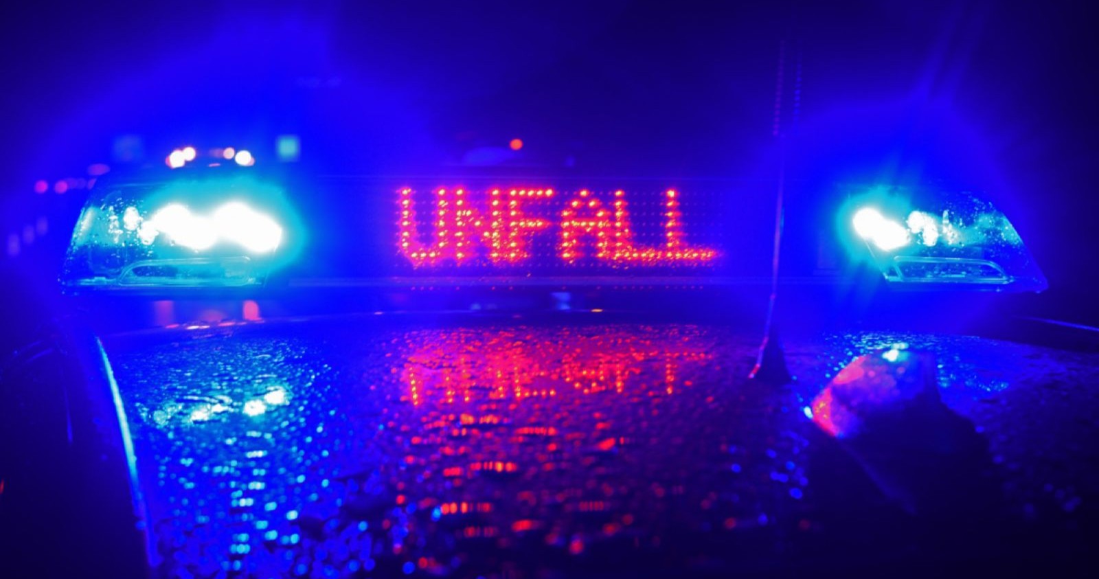 Polizei mit Unfall-Schild auf dem Wagen.