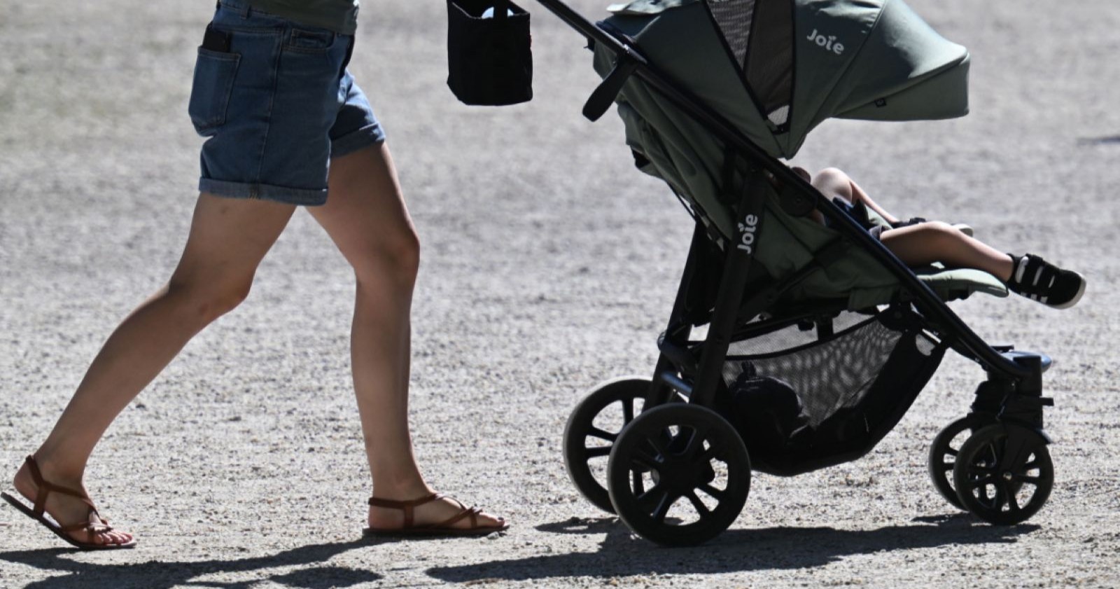 Eine Frau mit einem Kinderwagen.