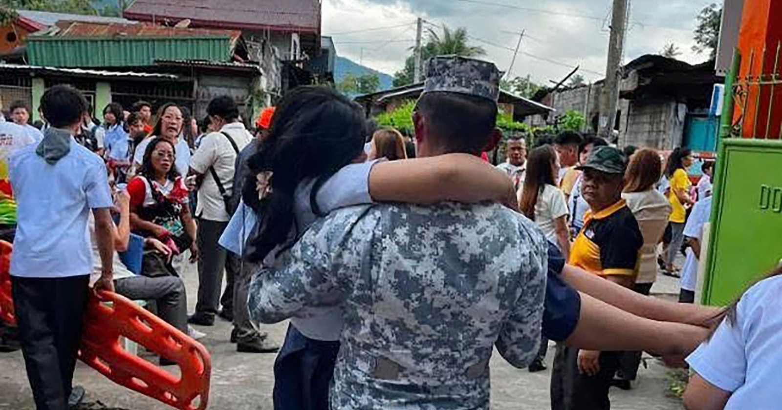 Rettungskräfte tragen verletzte Person nach Erdbeben auf den Philippinen durch Menschenmenge nach Tsunami-Warnung