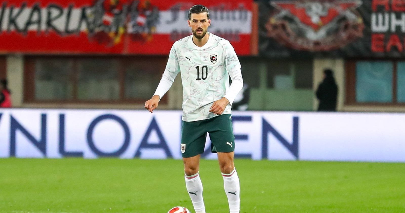 Ein Mann steht in Sportmontur am Fußballfeld