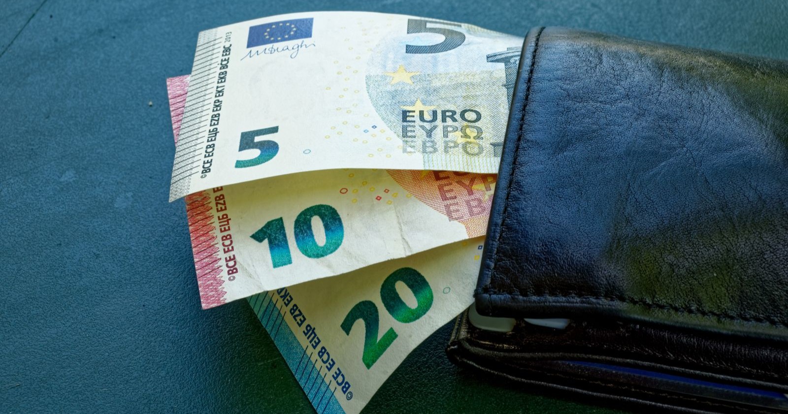 Geldbörse mit Euro-Scheinen und Münzen symbolisiert neue E-Card-Gebühren für Pensionisten und steigende finanzielle Belastung.