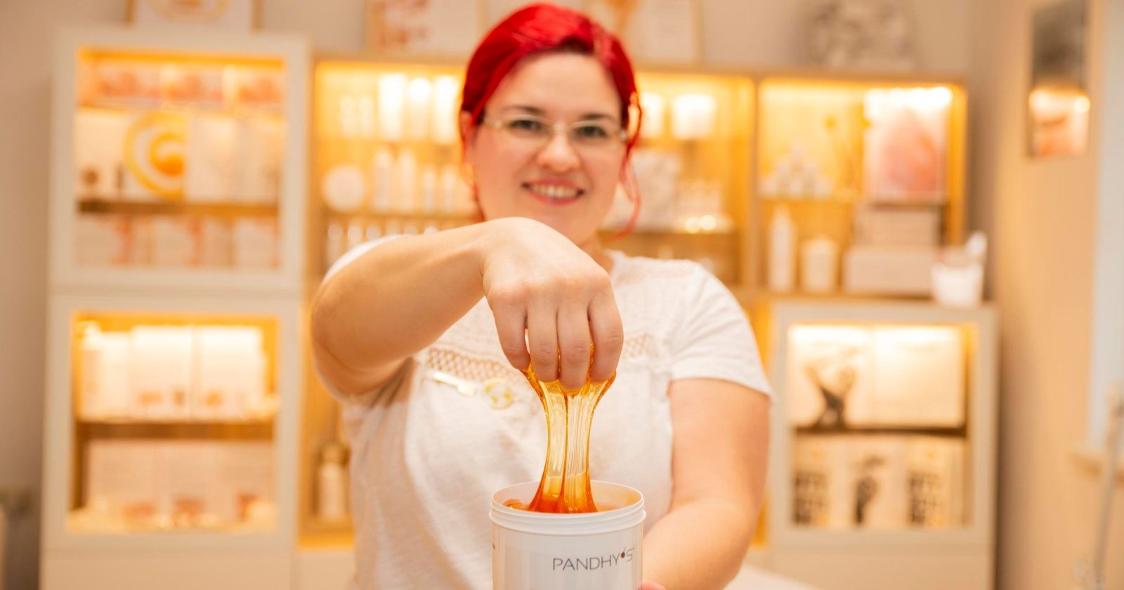 Frau mit roten Haaren greift in eine Paste