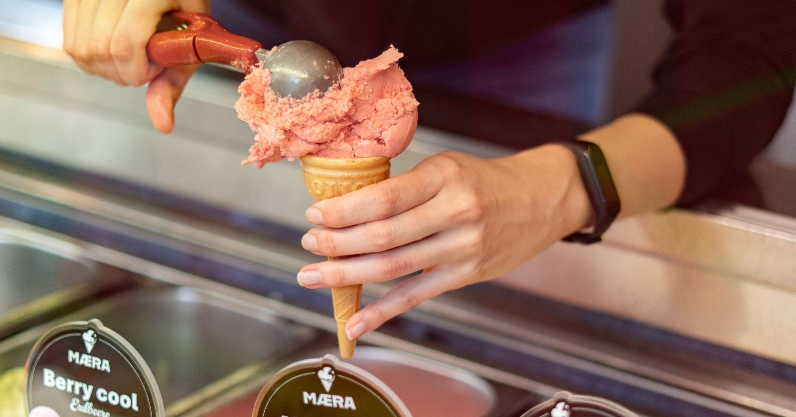 Frau gibt Kugel Eis in eine Tüte