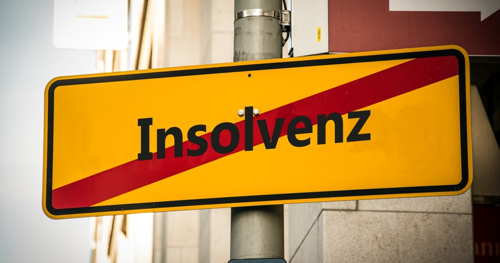 Ein Bild mit einem Wegweiser, der in zwei verschiedene Richtungen zeigt. Eine Richtung weist auf einen Neuanfang hin, die andere auf einen Bankrott.