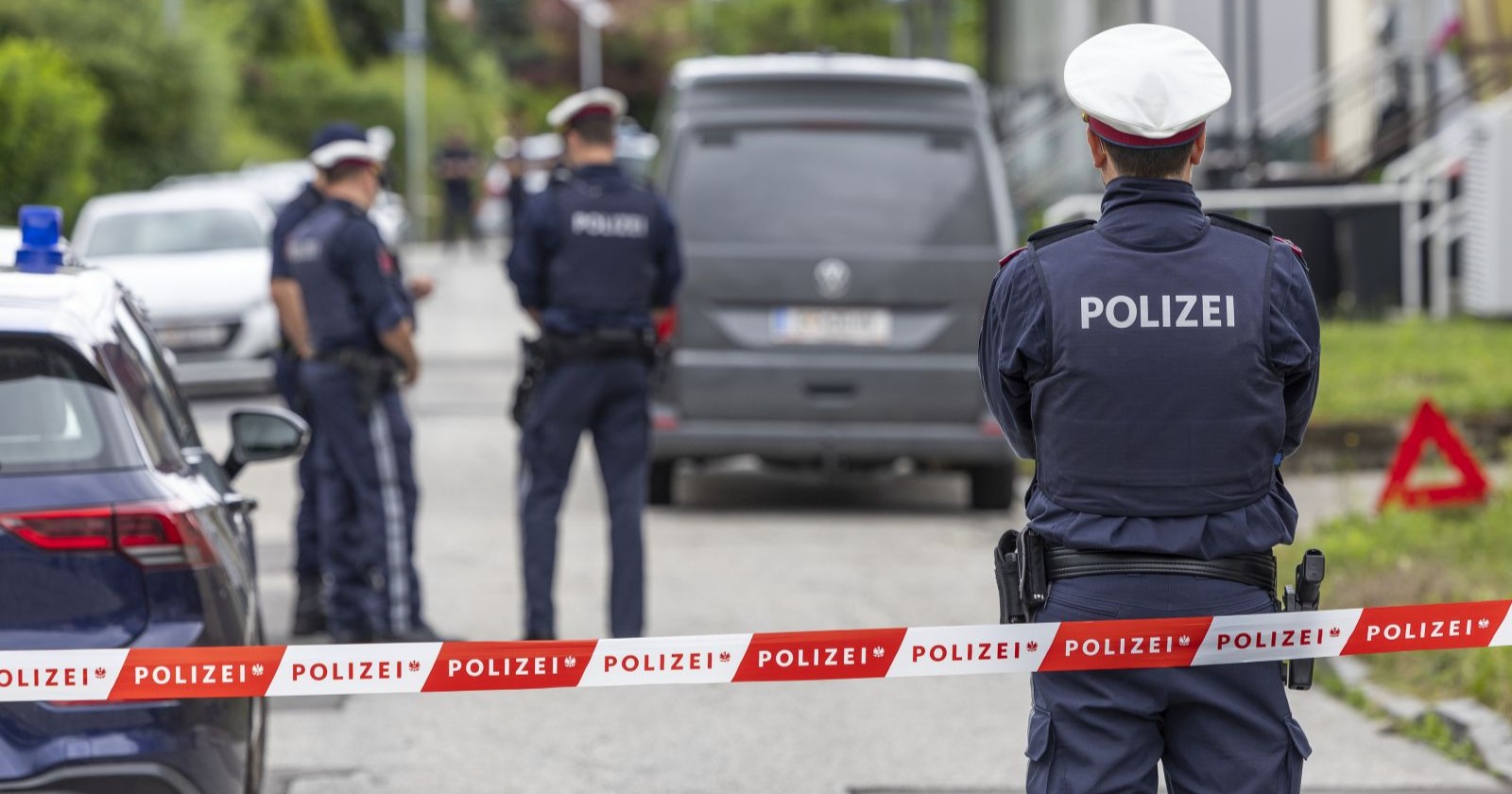 Polizeieinsatz mit Absperrband und Beamten nach Leichenfund in Klagenfurt St. Ruprecht