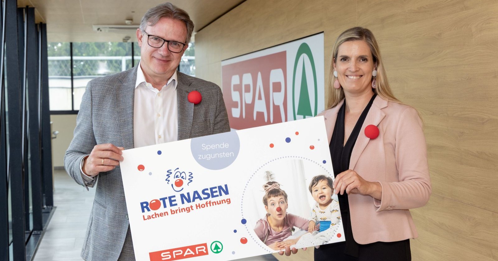 Zwei Menschen halten ein Schild in die Höhe