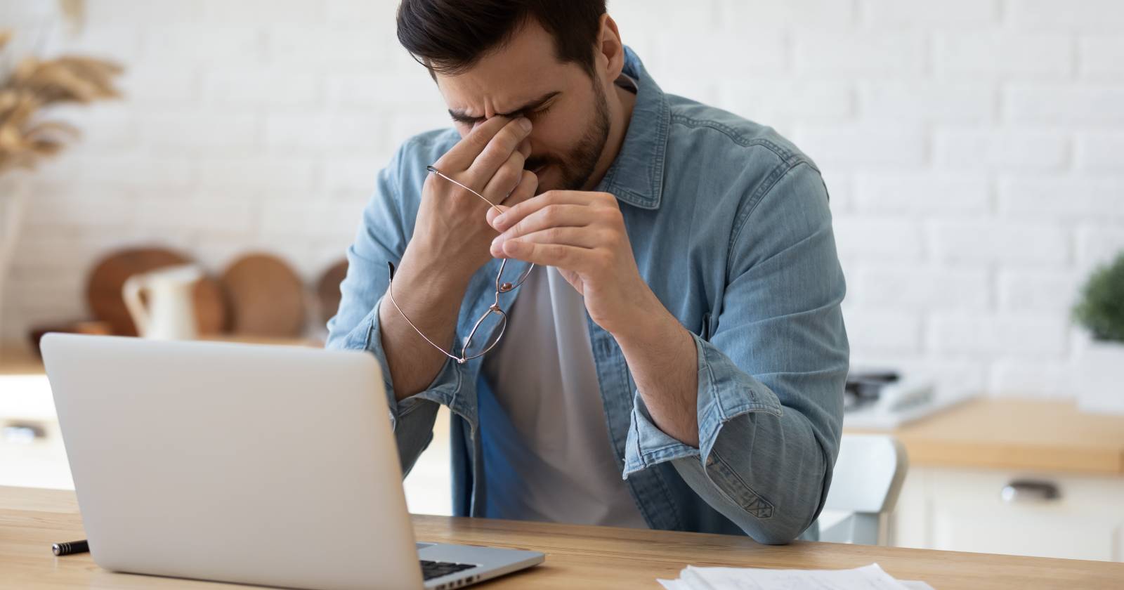 Mann sitzt vor Computer, reibt sich die Augen | Credit: fizkes/Shutterstock