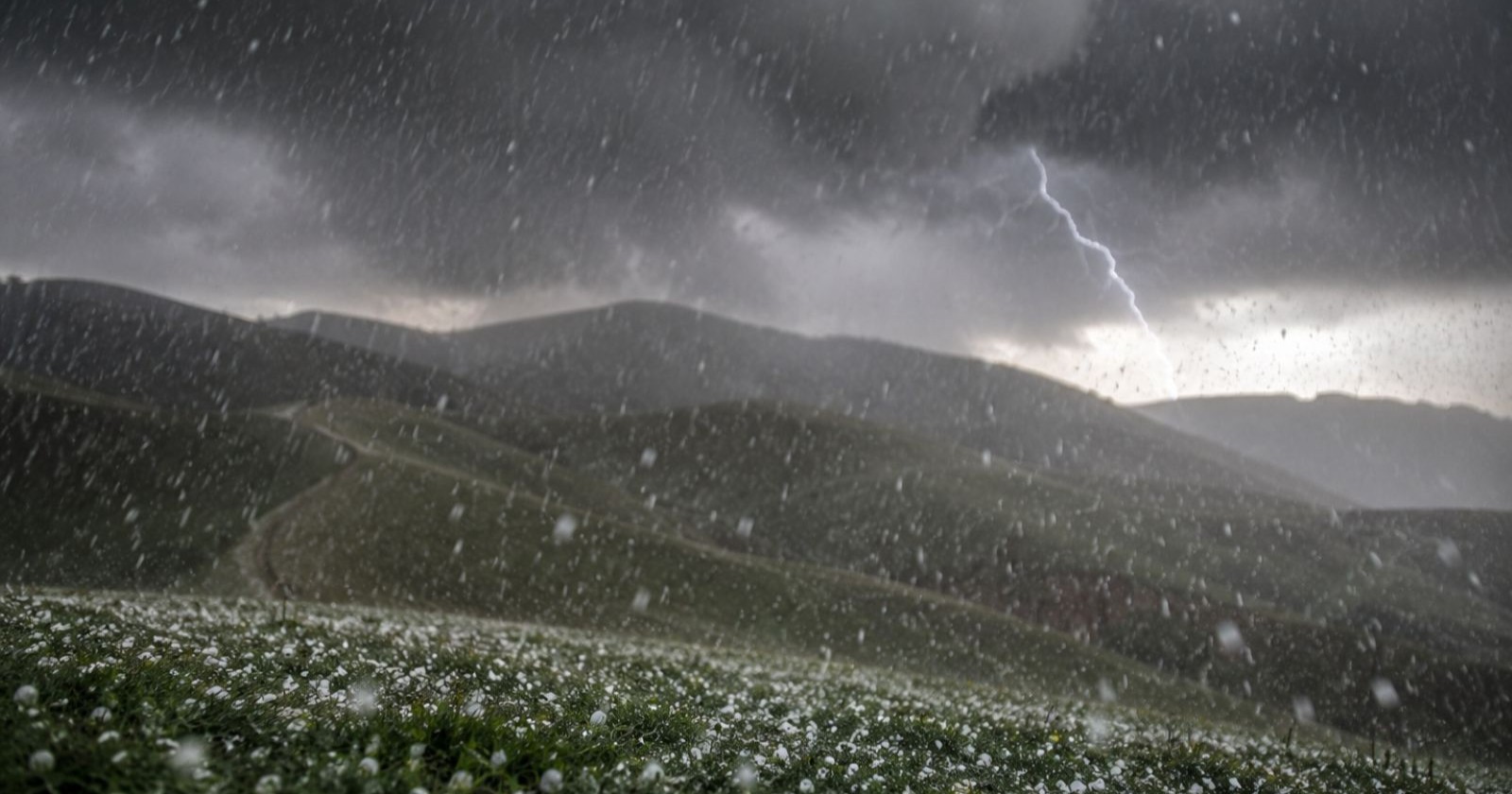 Gewitterwolken und fallende Hagelkörner als Themenbild für die Unwetter und Hagelwarnung in der Steiermark