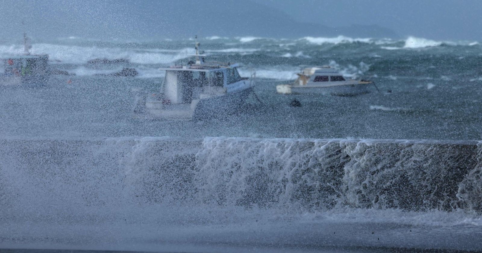Wellington Sturmflut mit hohen Wellen und starkem Wind, Boote im rauen Meer an der Küste Neuseelands