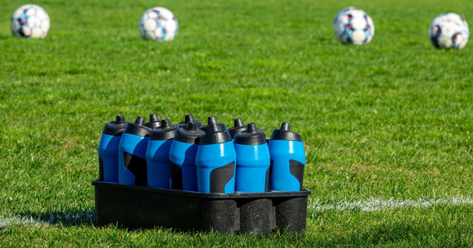 Mehrere Wasserflaschen auf einem Fußballfeld als Symbolbild für die Hydration Break bei der WM 2026
