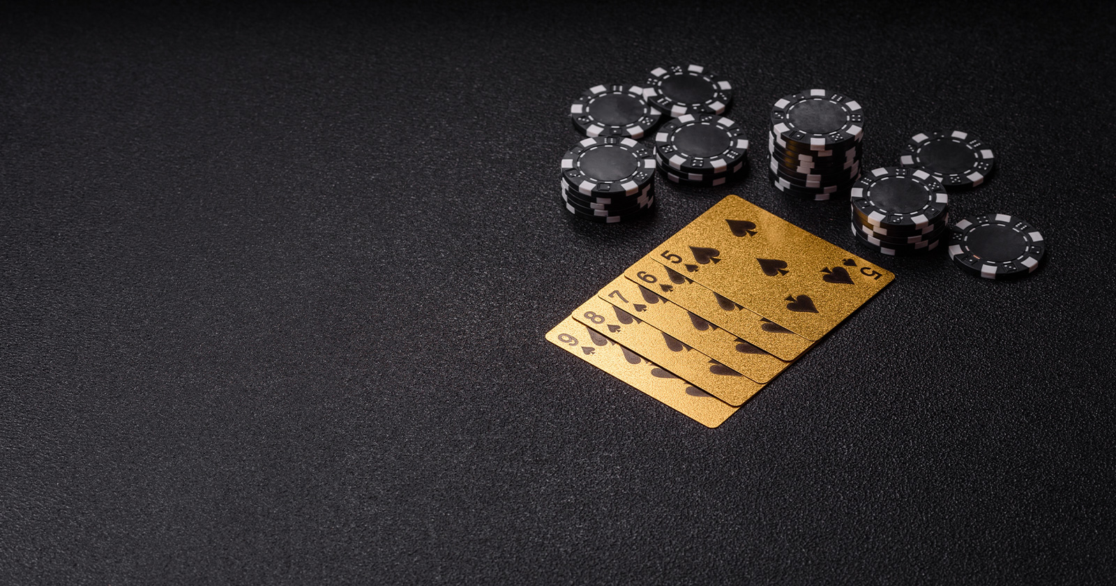 Goldene Spielkarten und Jetons auf dem Tisch | Credit: Tetiana Chernykova/Shutterstock