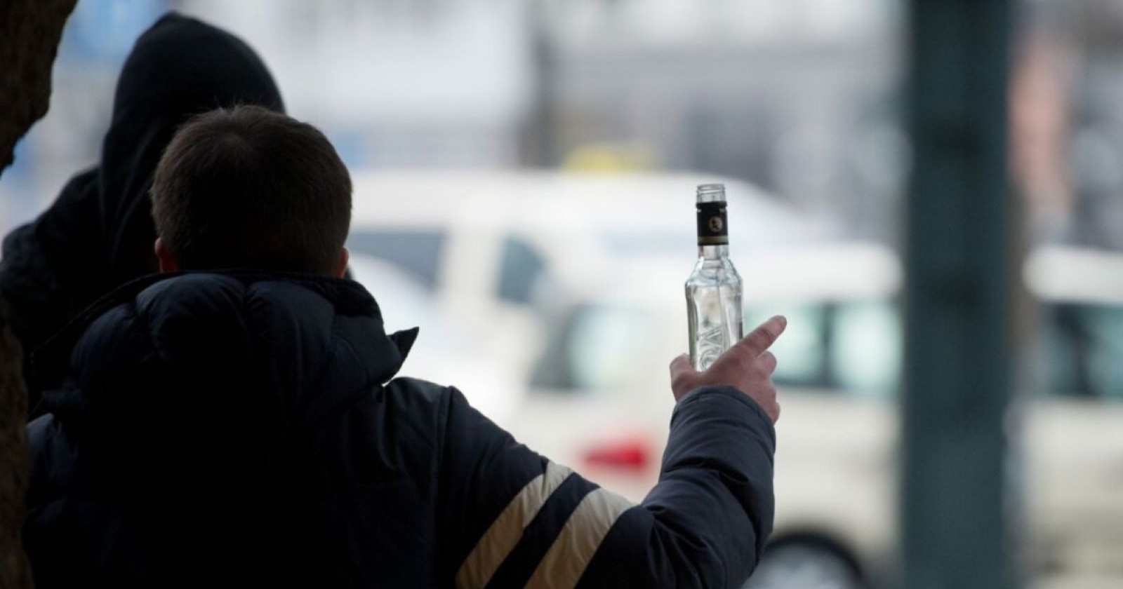 Person hält eine Alkoholflasche an einem Bahnhof – geplantes Alkoholverbot auf Bahnhöfen soll für mehr Sicherheit und weniger Konflikte sorgen.