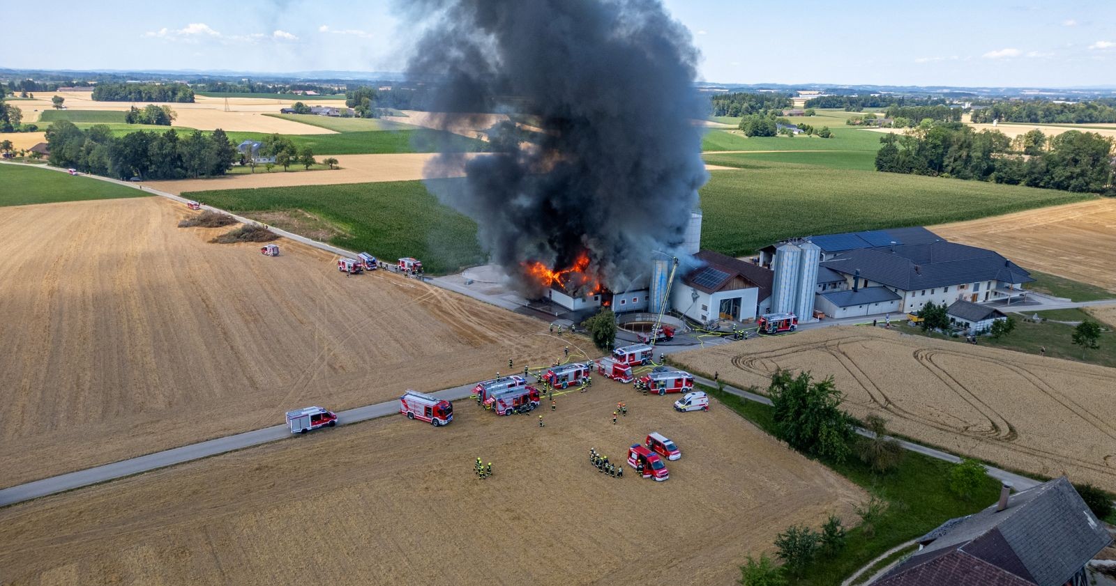 Ein Stallgebäude geht in Flammen auf und schwarzer Rauch ist zu sehen