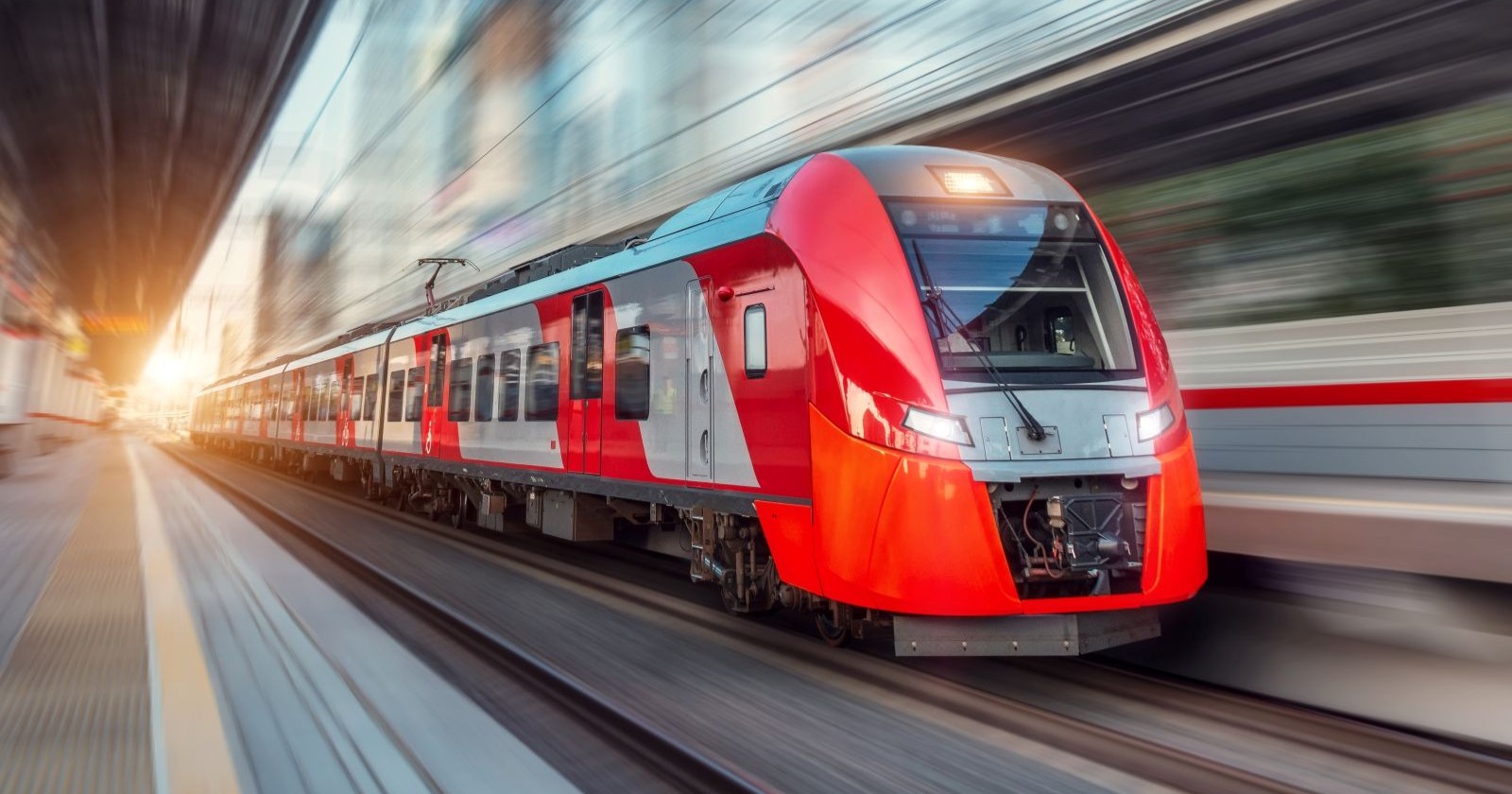 Ein roter Zug fährt in einen Bahnhof ein