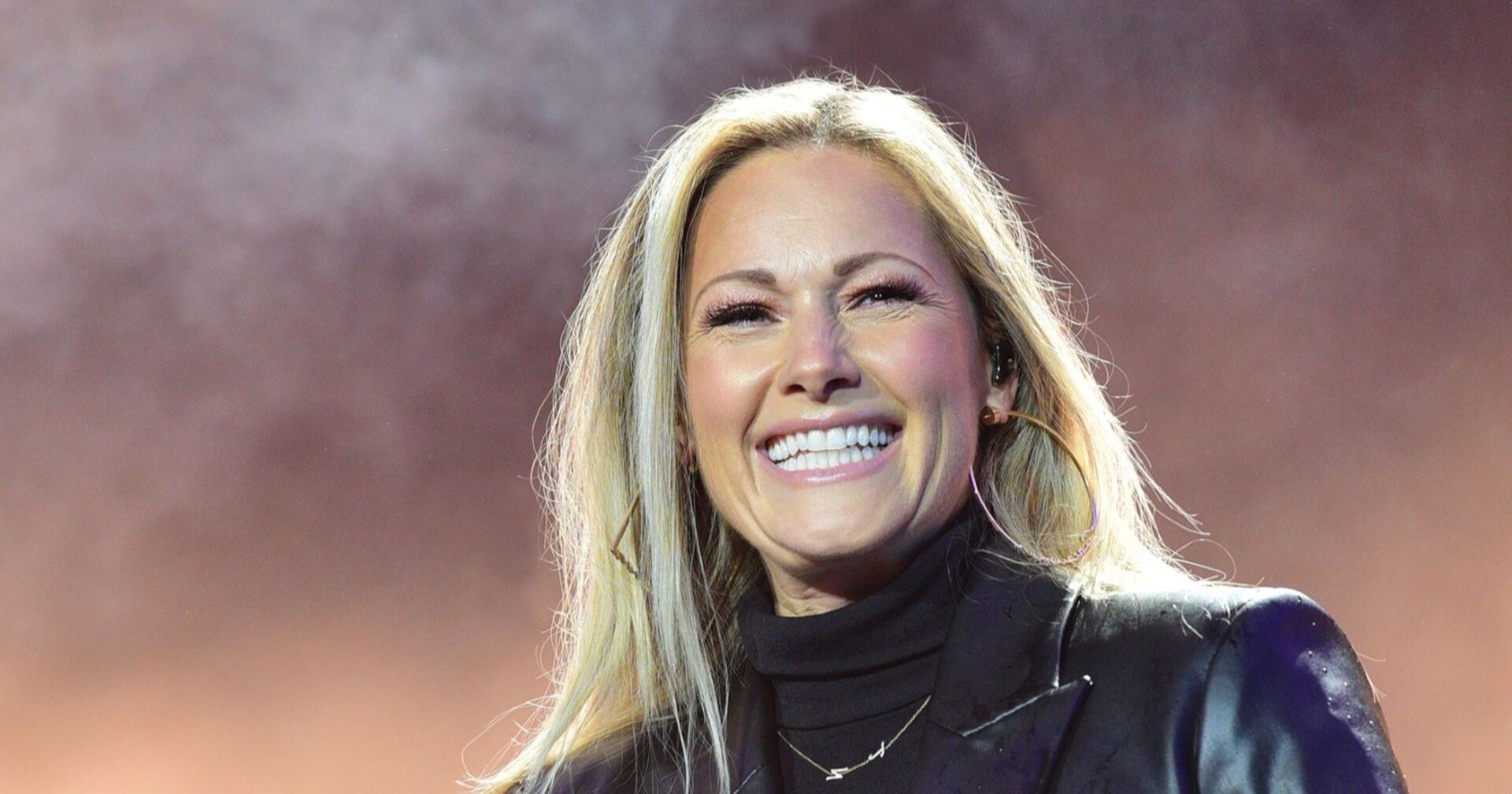 Helene Fischer bei einem Konzertauftritt auf der Bühne. Die Schlagersängerin lächelt und applaudiert während ihrer „360° Stadion Tour“.