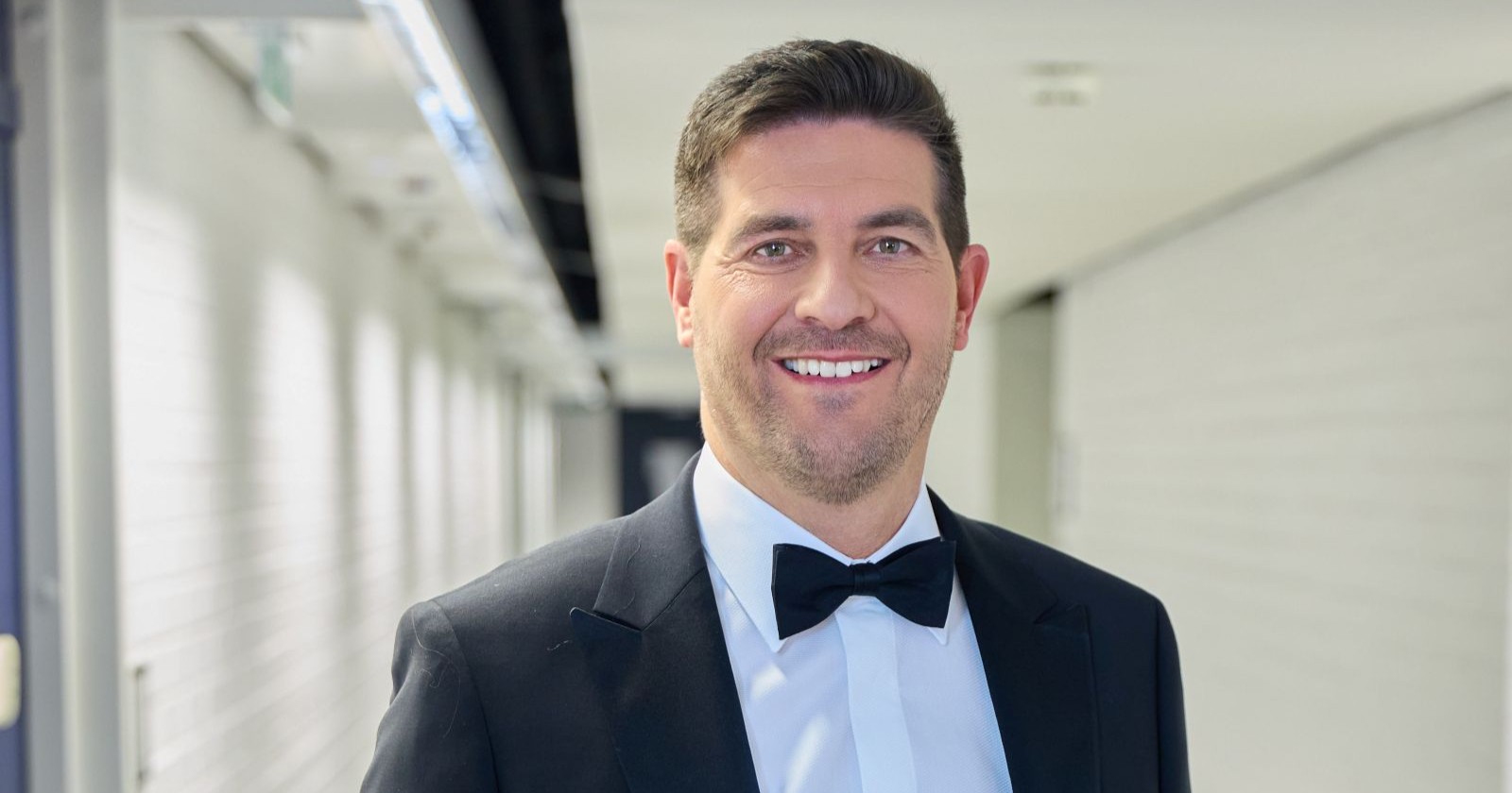 Norbert Oberhauser lächelt in einem schwarzen Smoking in die Kamera. Der ORF-Moderator zeigt nach der Geburt seiner Zwillinge auf Instagram emotionale Einblicke in sein Familienglück.