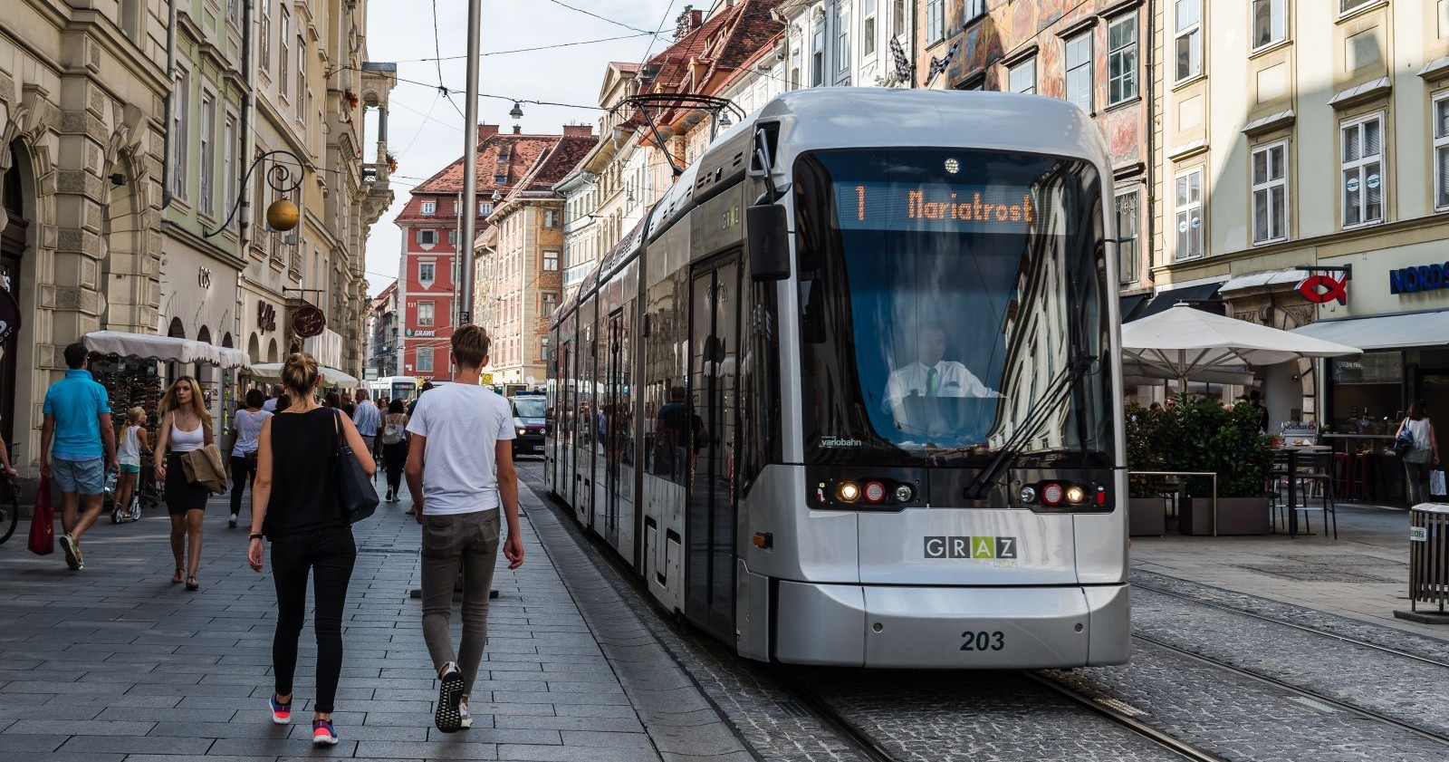 Eine Straßenbahn der Linie 1 fährt durch die Straßen von Graz