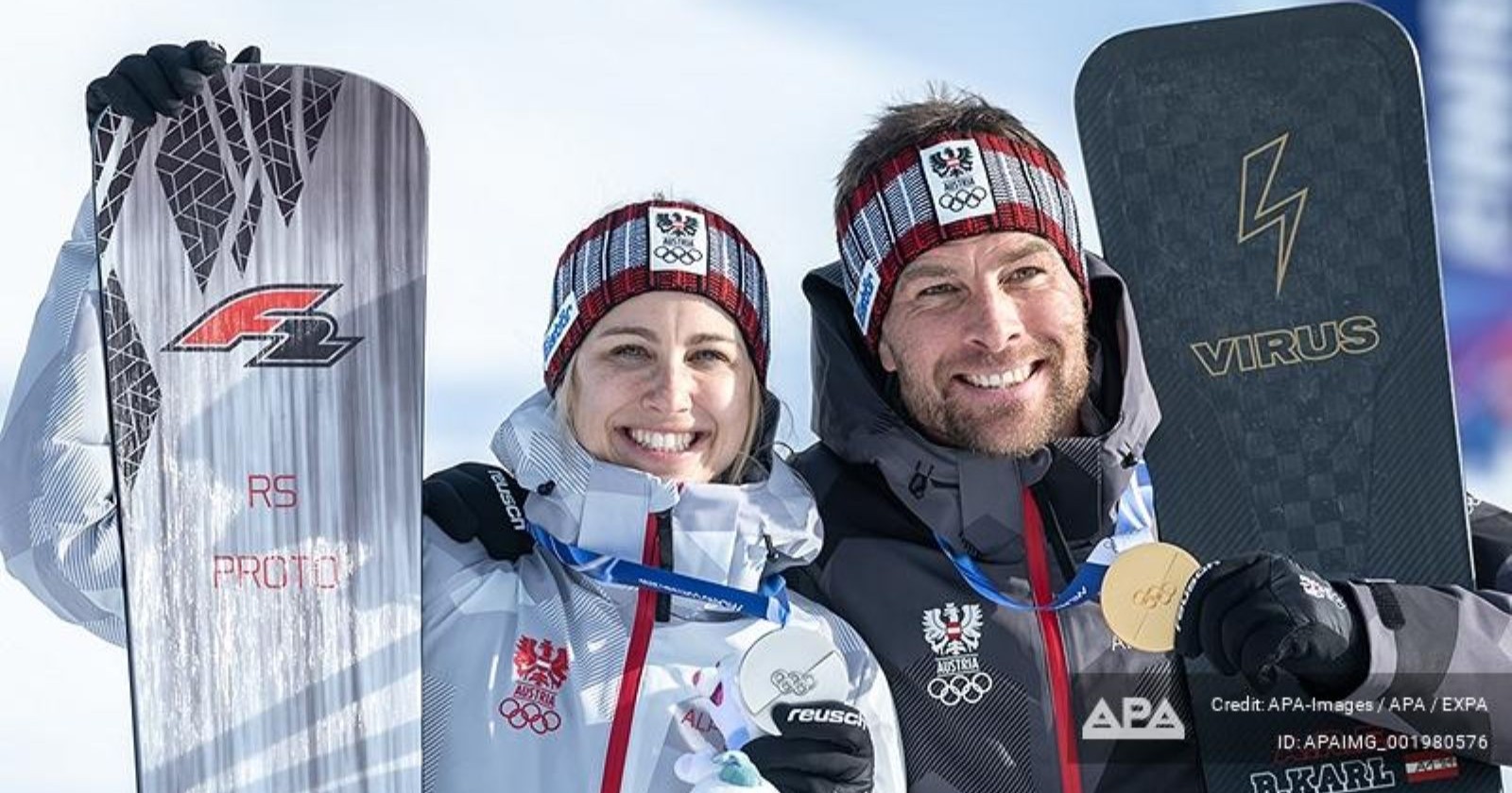 Sabine Payer strahlt gemeinsam mit ihrem Ehemann Alexander Payer nach einem erfolgreichen Wettkampf im österreichischen Nationalteam mit Snowboards und Olympia-Medaille.