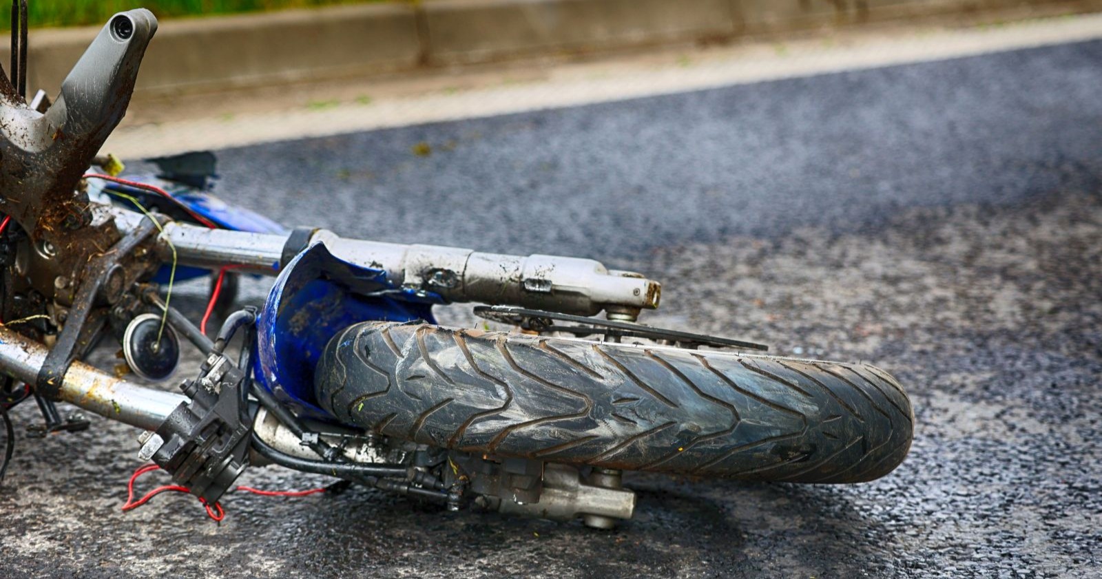Ein beschädigtes Motorrad liegt nach einem schweren Verkehrsunfall am Straßenrand