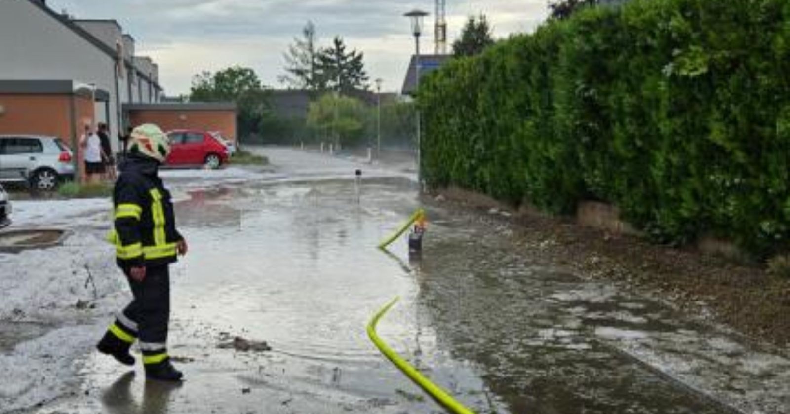 Feuerwehr bei Einsatz auf überfluteter Straße nach Starkregen in Wiener Neustadt Niederösterreich Wasser steht auf Fahrbahn