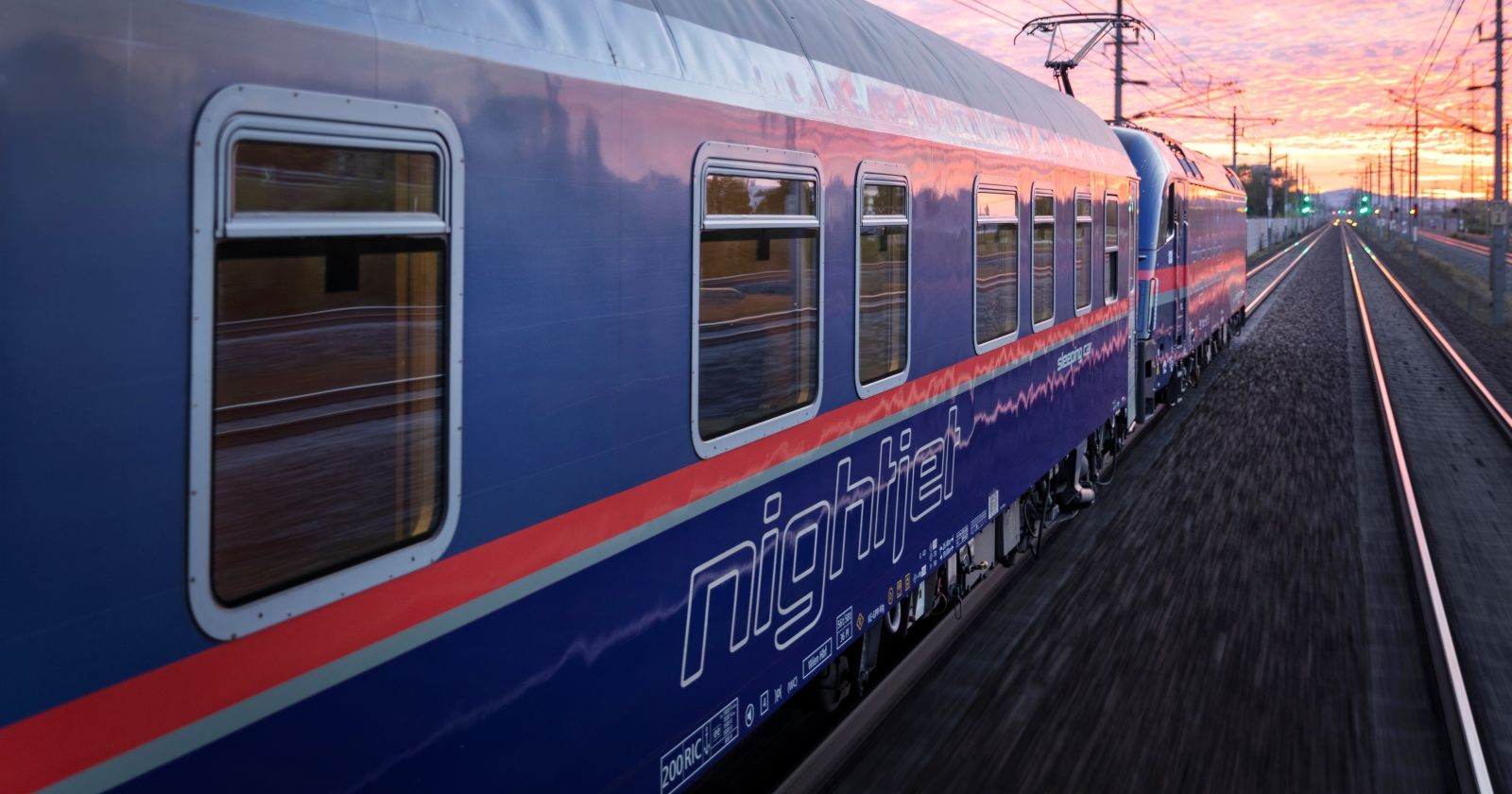 Ein ÖBB-Nachtzug fährt durch eine ländliche Region auf der Weststrecke zwischen Amstetten und Linz