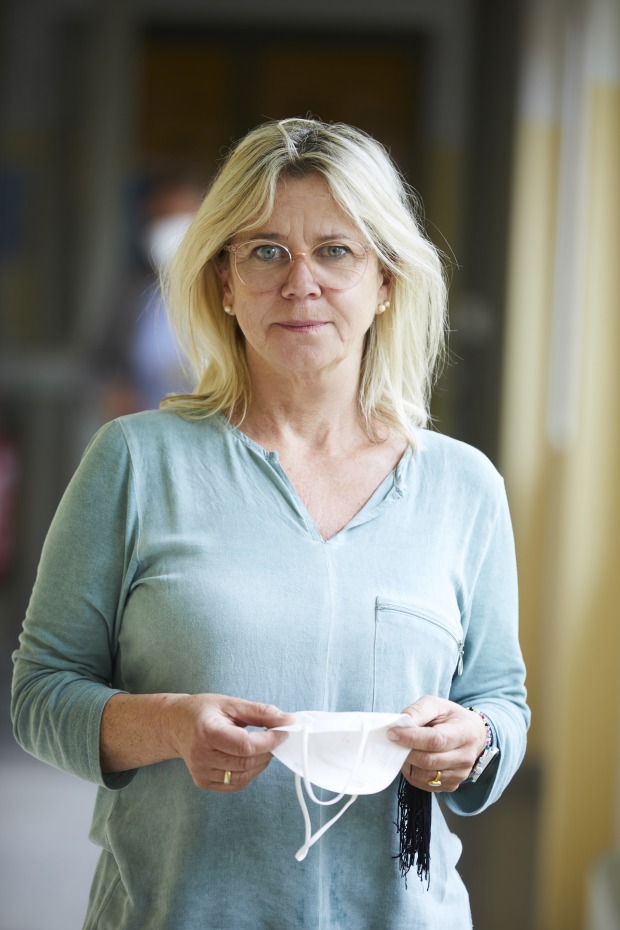 Porträt von Petra Erian, die eine FFP2-Schutzmaske in Händen hält