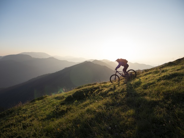 Mann fährt mit Mountainbike einen Berg hinunter