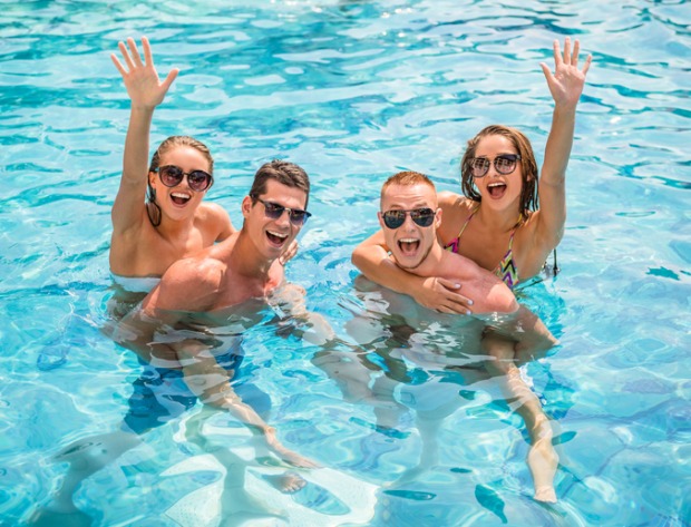 Zwei Pärchen plantschen im Schwimmbad
