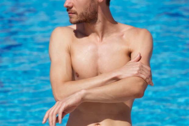 Mann mit nacktem Oberkörper im Pool