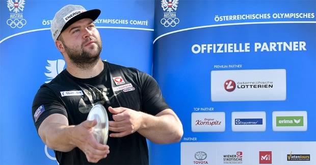 Lukas Weißhaidinger mit schwarzem Shirt und grauen Cap bei der offiziellen Vorstellung des österreichischen ÖOC-Kaders mit einem Diskus in der Hand.