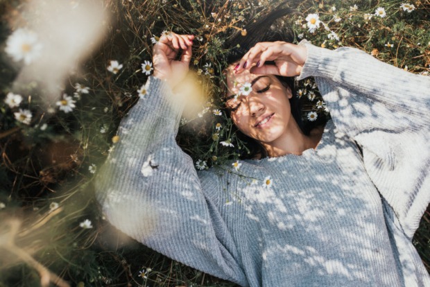 Frau liegt in der Wiese unter freiem Himmel | Credit: iStock.com/Yuricazac