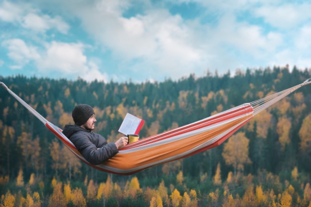 Mann liest in der Hängematte | Credit: iStock.com/happyphoton