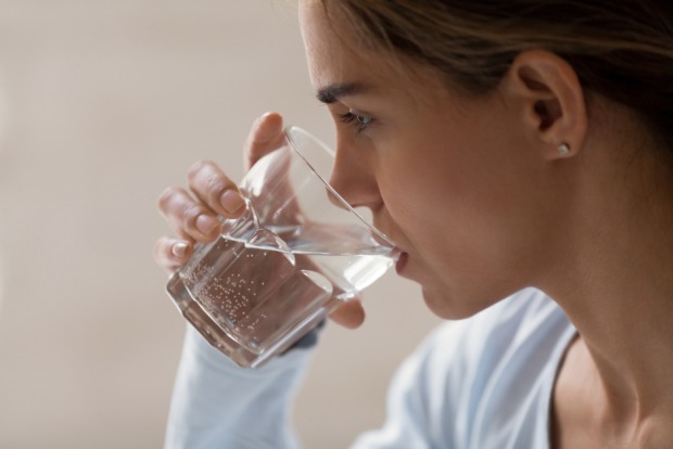 Frau trinkt ein Glas Wasser | Credit: iStock.com/fizkes